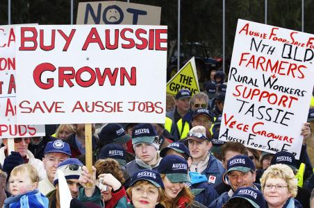 Protestors wearing Aus-Veg caps beneath 'Buy Aussie grown' placard