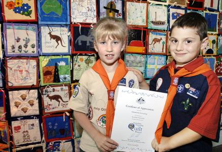 2 young scouts hold a paper certificate