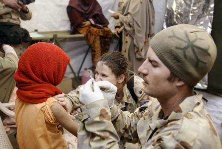 A child waits for an injection from a medic 