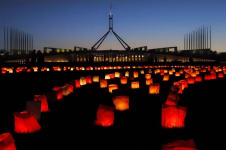 Silhouette of parliament house above glowing orange lanterns