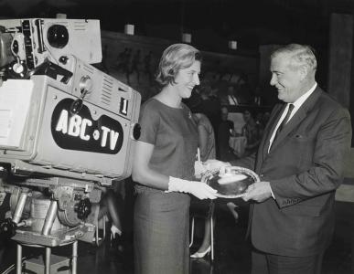 2 poeple standing beside an ABC TV studio camera.