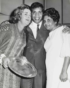 An athlete poses with 2 women