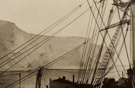 A close view through ship rigging of an ice cliff .
