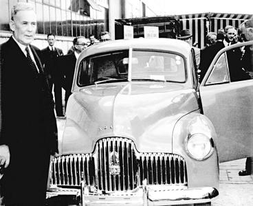 Australian Prime Minister Ben Chifley stands beside Australia's first Holden sedan.