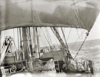 View beneath sail through rigging toward the horizon.