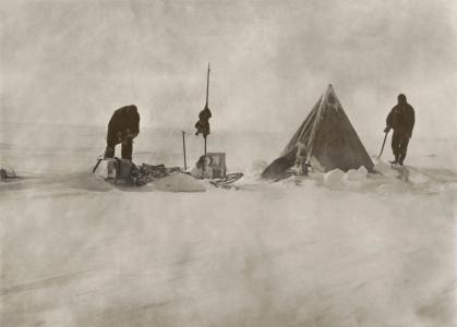 2 men beside a tent and sled in snow