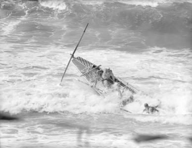 A surf boat swamped by a wave