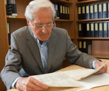Laszlo Makay reading his migration documents at a table. 