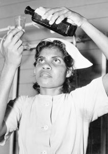 Aboriginal nurse pouring medicine