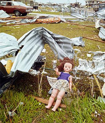 A doll amongst building material caught on a fence.